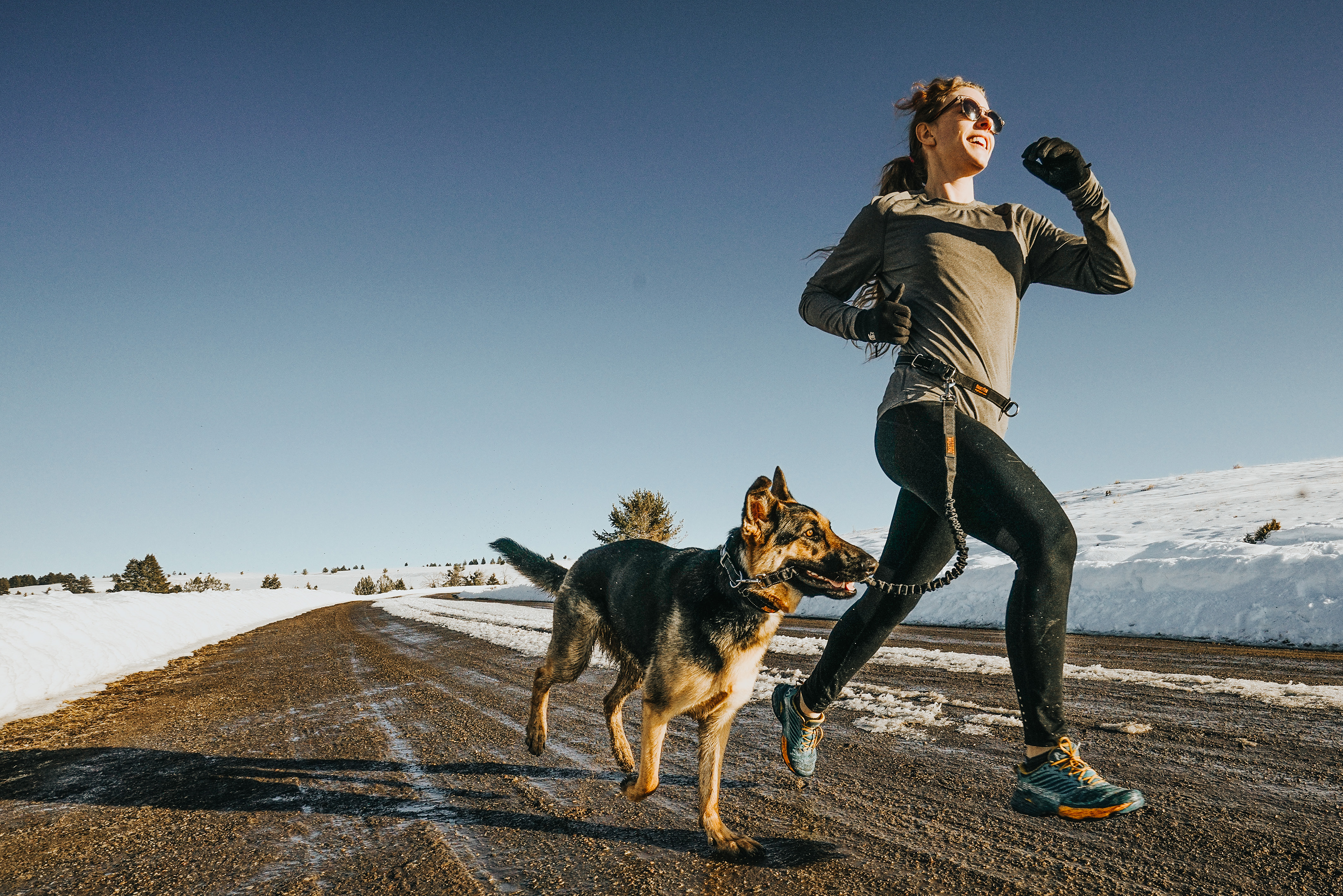 Woman running on street with dog using Mighty Paw Hands Free Leash with snow on the ground.